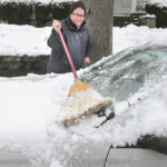Kevin Leyden sweeps snow off his windshield